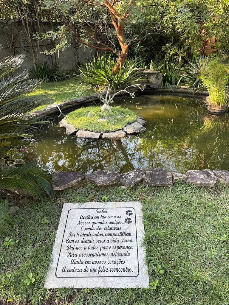 Placa com oração de homenagem aos animais ao lado do lago do jardim memorial